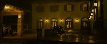 Movie still from “Marlowe” (2022), directed by Neil Jordan – An old car parked in front of a building at night; Extreme Wide shot, Low angle