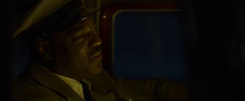Movie still from “Marlowe” (2022), directed by Neil Jordan – A man wearing a hat sitting in a car at night; Close Up shot, Low angle