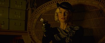 Movie still from “Marlowe” (2022), directed by Neil Jordan – A woman holding a cell phone while wearing a hat; Close Up shot, Low angle