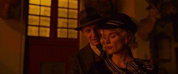 Movie still from “Marlowe” (2022), directed by Neil Jordan – An older man and a younger woman wearing hats; Close Up shot, Low angle