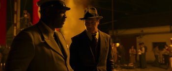 Movie still from “Marlowe” (2022), directed by Neil Jordan – A man in a suit and hat standing next to another man in a suit; Medium shot, Low angle