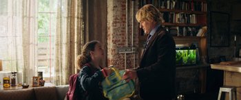 Movie still from “Marry Me” (2022), directed by Kat Coiro – A man and a little girl are exchanging gifts; Medium shot, Over the shoulder angle
