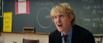 Movie still from “Marry Me” (2022), directed by Kat Coiro – A man with blonde hair wearing a suit and tie; Close Up shot, Over the shoulder angle