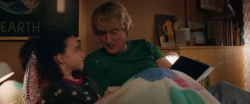 Movie still from “Marry Me” (2022), directed by Kat Coiro – A woman and a child are looking at a book together; Close Up shot, Over the shoulder angle