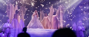 Movie still from “Marry Me” (2022), directed by Kat Coiro – A group of women dressed up as angels on a stage; Wide shot, Low angle
