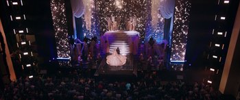 Movie still from “Marry Me” (2022), directed by Kat Coiro – A woman in a white dress on a stage; Extreme Wide shot, High angle