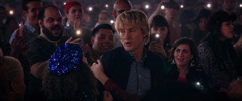 Movie still from “Marry Me” (2022), directed by Kat Coiro – A group of people standing in front of a crowd; Medium shot, Over the shoulder angle