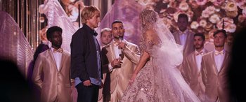 Movie still from “Marry Me” (2022), directed by Kat Coiro – Two men and a woman are standing in front of each other; Wide shot, Over the shoulder angle