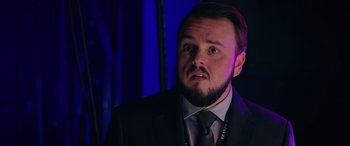 Movie still from “Marry Me” (2022), directed by Kat Coiro – A man in a suit and a tie looking surprised; Close Up shot, Over the shoulder angle
