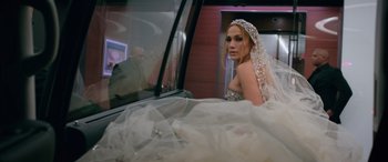Movie still from “Marry Me” (2022), directed by Kat Coiro – A woman in a wedding dress looking out of a car window; Medium shot, Over the shoulder angle