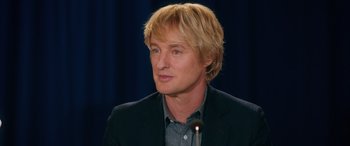 Movie still from “Marry Me” (2022), directed by Kat Coiro – A person wearing a suit and tie; Close Up shot, Over the shoulder angle