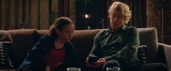 Movie still from “Marry Me” (2022), directed by Kat Coiro – A woman sitting next to a young girl on a couch; Medium shot, Over the shoulder angle