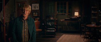 Movie still from “Marry Me” (2022), directed by Kat Coiro – A man standing in a living room next to a table; Medium shot, Over the shoulder angle