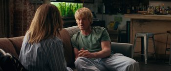 Movie still from “Marry Me” (2022), directed by Kat Coiro – A man sitting on a couch talking to a woman; Medium shot, Over the shoulder angle