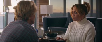 Movie still from “Marry Me” (2022), directed by Kat Coiro – Two people sitting at a table with a bowl of food; Medium shot, Over the shoulder angle