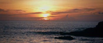 Movie still from “Marry Me” (2022), directed by Kat Coiro – The sun is setting over the ocean with the sky in the background; Extreme Wide shot, Low angle