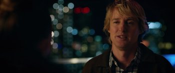 Movie still from “Marry Me” (2022), directed by Kat Coiro – A man standing in front of a city at night; Close Up shot, Over the shoulder angle