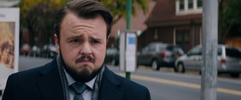 Movie still from “Marry Me” (2022), directed by Kat Coiro – A person wearing a suit and tie; Close Up shot, Over the shoulder angle