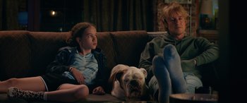 Movie still from “Marry Me” (2022), directed by Kat Coiro – A woman and a girl sitting on a couch next to a dog; Medium shot, Over the shoulder angle