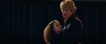 Movie still from “Marry Me” (2022), directed by Kat Coiro – A man and a girl are standing next to each other; Medium shot, Over the shoulder angle