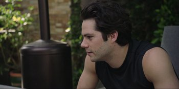 Movie still from “Maximum Truth” (2023), directed by David Stassen – A young man sitting down with his head resting on his arm; Close Up shot, Over the shoulder angle