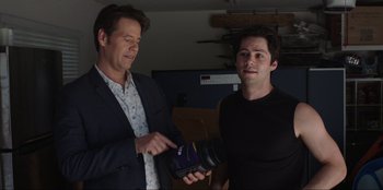 Movie still from “Maximum Truth” (2023), directed by David Stassen – Two men standing next to each other in a room; Medium shot, Over the shoulder angle