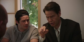 Movie still from “Maximum Truth” (2023), directed by David Stassen – Two men are sitting at a table and one of the men is pointing; Close Up shot, Over the shoulder angle