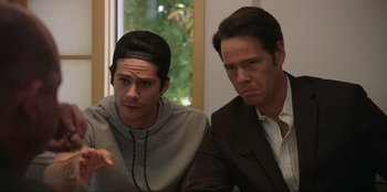 Movie still from “Maximum Truth” (2023), directed by David Stassen – Two men sitting next to each other in front of a window; Medium shot, Over the shoulder angle