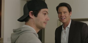 Movie still from “Maximum Truth” (2023), directed by David Stassen – A man and a man wearing a baseball cap; Close Up shot, Over the shoulder angle