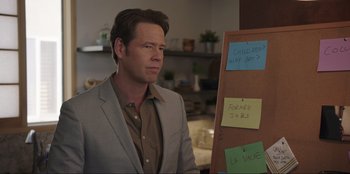 Movie still from “Maximum Truth” (2023), directed by David Stassen – A man standing in front of a board with sticky notes on it; Medium shot, Over the shoulder angle