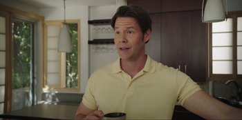 Movie still from “Maximum Truth” (2023), directed by David Stassen – A person holding a coffee cup; Medium shot, Over the shoulder angle