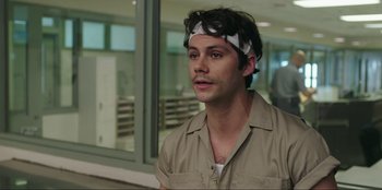 Movie still from “Maximum Truth” (2023), directed by David Stassen – A man with a bandage on his head is standing in front of a window; Close Up shot, Over the shoulder angle