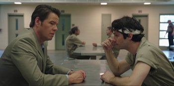 Movie still from “Maximum Truth” (2023), directed by David Stassen – Two men sitting at a table in a room; Close Up shot, Over the shoulder angle