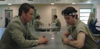 Movie still from “Maximum Truth” (2023), directed by David Stassen – A couple of men sitting next to each other at a table; Medium shot, Over the shoulder angle