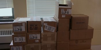 Movie still from “Mayor Pete” (2021), directed by Jesse Moss – Boxes stacked on top of each other in front of a window; Wide shot, High angle