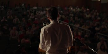 A man standing in front of an audience with a microphone