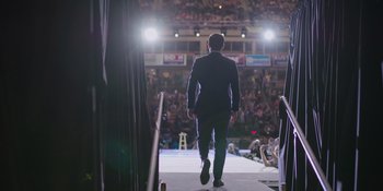 A man walking down a runway in front of an audience