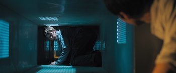 Movie still from “Maze Runner: The Scorch Trials” (2015), directed by Wes Ball – A man is sitting on the ground in a room; Wide shot, Low angle