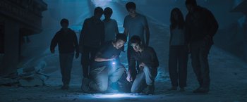 Movie still from “Maze Runner: The Scorch Trials” (2015), directed by Wes Ball – A group of people standing around a light; Wide shot, High angle