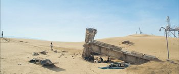 Movie still from “Maze Runner: The Scorch Trials” (2015), directed by Wes Ball – Some people are sitting in the sand near a broken structure; Extreme Wide shot, High angle