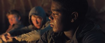 Movie still from “Maze Runner: The Scorch Trials” (2015), directed by Wes Ball – A young man crying while sitting next to a young woman; Close Up shot, Low angle
