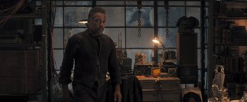 Movie still from “Maze Runner: The Scorch Trials” (2015), directed by Wes Ball – A man standing in front of a window in a room; Medium shot, Low angle