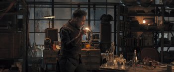 Movie still from “Maze Runner: The Scorch Trials” (2015), directed by Wes Ball – A man holding a lit candle in a room; Medium shot, Low angle