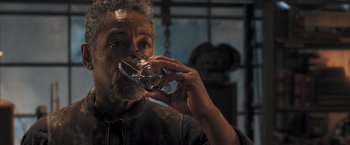 Movie still from “Maze Runner: The Scorch Trials” (2015), directed by Wes Ball – An older man drinking a glass of wine; Close Up shot, High angle