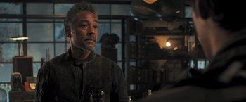 Movie still from “Maze Runner: The Scorch Trials” (2015), directed by Wes Ball – A man sitting at a table with a glass of wine; Close Up shot, Over the shoulder angle