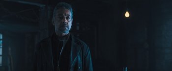 Movie still from “Maze Runner: The Scorch Trials” (2015), directed by Wes Ball – A man in a black jacket standing in a dark room; Close Up shot, Low angle