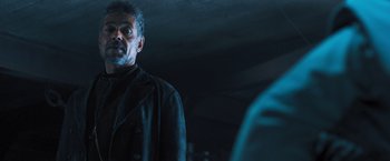 Movie still from “Maze Runner: The Scorch Trials” (2015), directed by Wes Ball – A man standing in a dark room looking at the camera; Medium shot, Over the shoulder angle