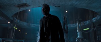 Movie still from “Maze Runner: The Scorch Trials” (2015), directed by Wes Ball – A man standing in a dark room wearing headphones; Medium shot, Low angle