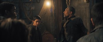 Movie still from “Maze Runner: The Scorch Trials” (2015), directed by Wes Ball – A man standing next to a young boy in a room; Medium shot, Over the shoulder angle