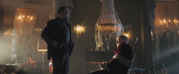 Movie still from “Maze Runner: The Scorch Trials” (2015), directed by Wes Ball – Two men are talking in a dimly - lit room; Medium shot, Over the shoulder angle